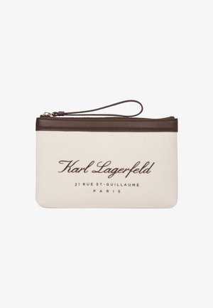 Beige canvas tasje met bruine leren accenten en een polsbandje, met geperste tekst: "Karl Lagerfeld" en locatiegegevens.