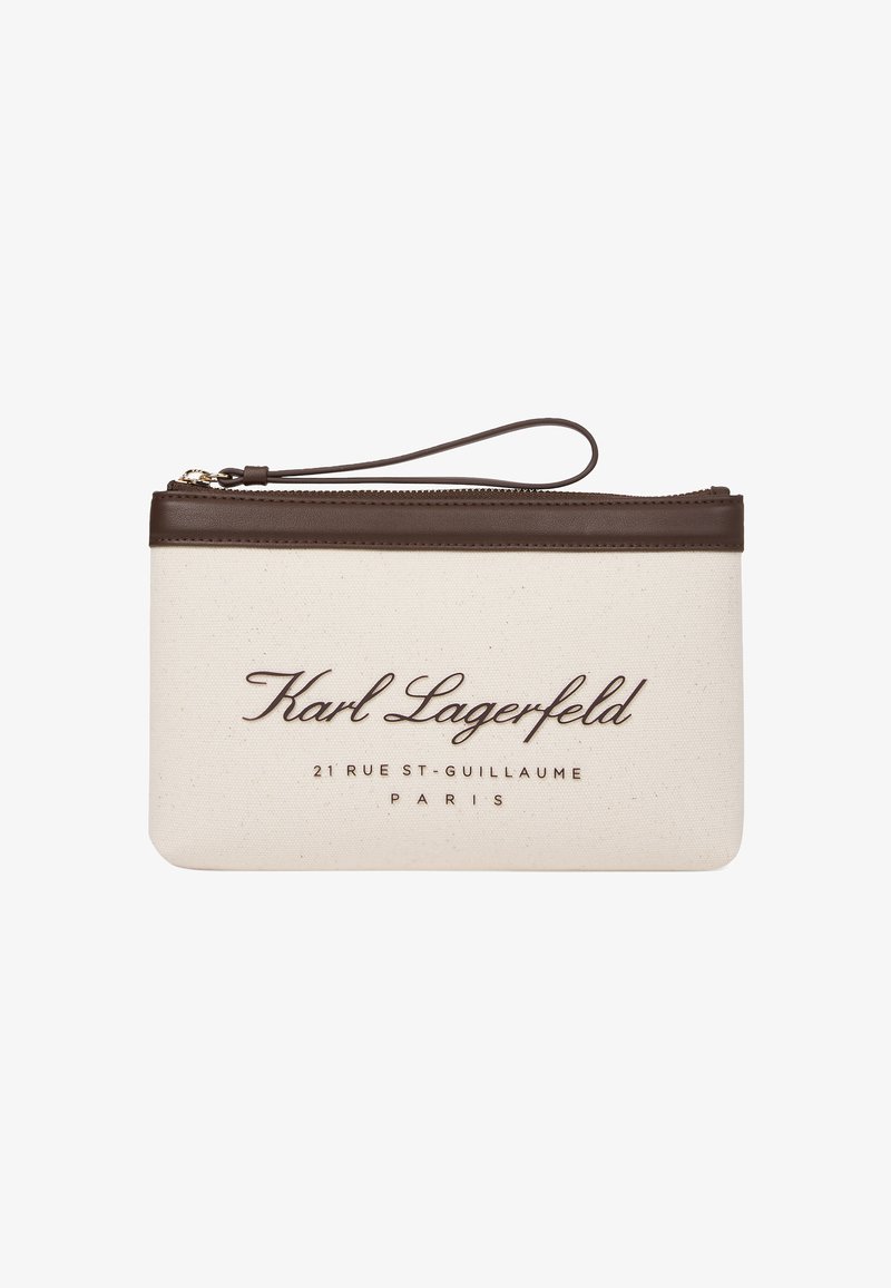 Pochette en toile beige avec des accents en cuir marron et une lanière pour le poignet, avec un texte embossé : « Karl Lagerfeld » et des détails de localisation.