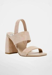 Sandalo con tacco in suede beige caratterizzato da una larga fascetta anteriore, un cinturino regolabile sul retro e un tacco quadrato spesso per maggiore stabilità.