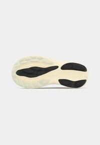 Sål av sko med en kombinasjon av off-white og svart gummi, med et teksturert mønster forgrep og en merkbar kurve i designet.