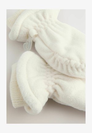 Mehki beli flisasti rokavici z rebrastimi manšetami, povezani s plastično sponko, leže na ravni svetli površini.