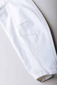Λευκό παντελόνι από τζιν με ευθεία γραμμή ποδιού, διπλές μπροστινές τσέπες και αντίθετη ραφή σε ταμπά χρώμα κατά μήκος των ραφών.