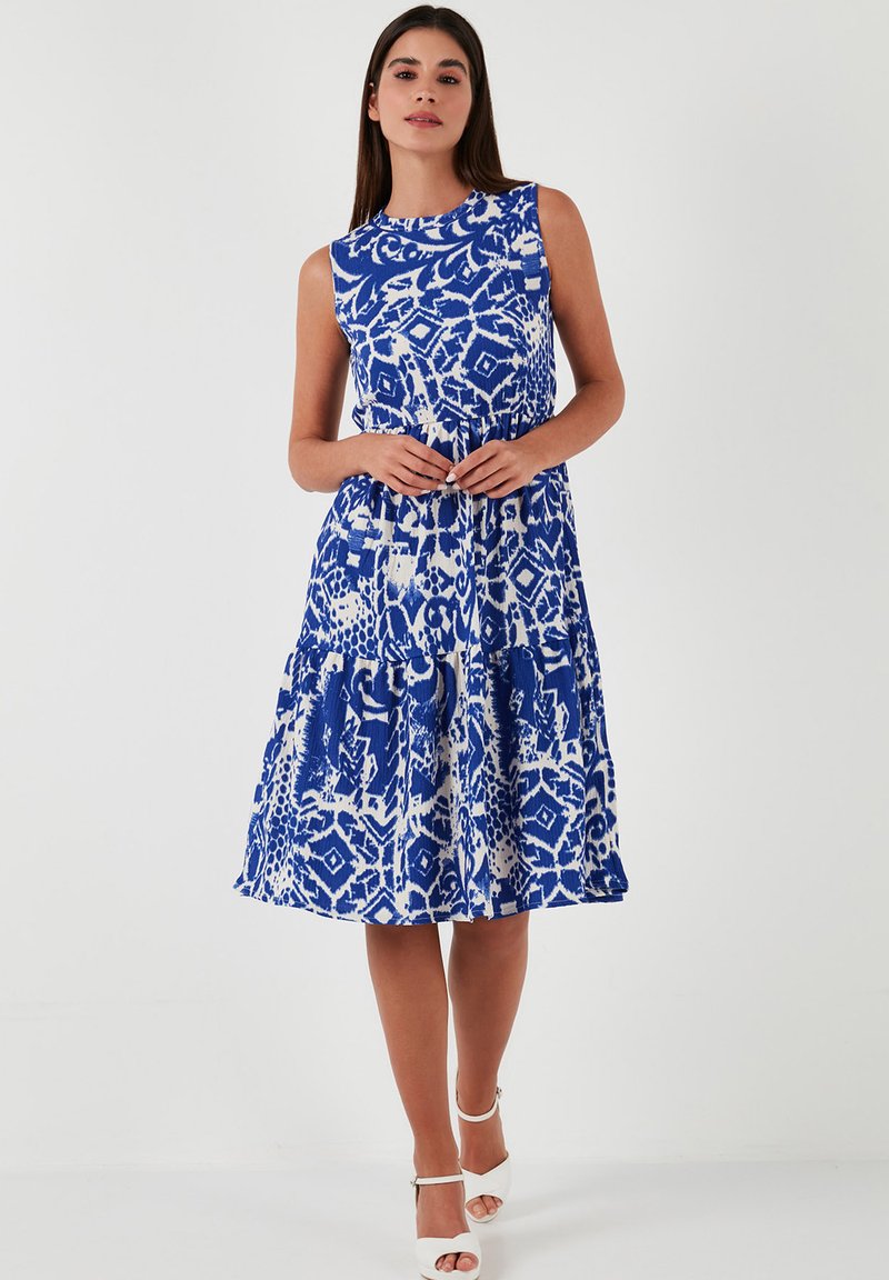Blue and white patterned sleeveless dress with a flared skirt, featuring a round neckline and gathered detail at the waist.