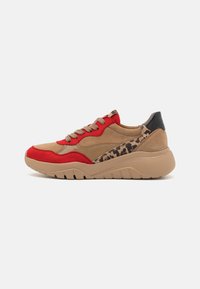 Tan and red sneaker featuring a mix of suede and textile materials, a leopard print accent, and a thick rubber sole with contoured grooves.