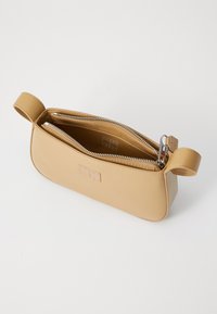 Beige, rektangulær kosmetikkveske i l�ær med glidelås og to innvendige rom. Har sidehåndtak og preget logodetalj.