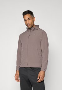 Gray Nike jacket with a zip front, adjustable hood, and two front pockets. Made from a lightweight, smooth material with elastic cuffs.