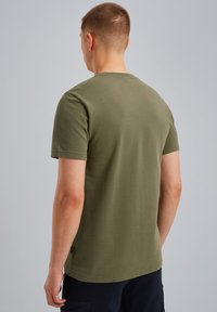 Camiseta corta de color verde oliva, con mangas cortas, textura acanalada, diseño de cuello redondo, hecha de algodón, con una pequeña etiqueta en la costura lateral.