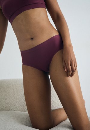 Sous-vêtements en mélanger coton bordeaux avec une coupe taille basse, présentant une texture lisse et des coutures minimales, accompagnés d'un crop top assorti.