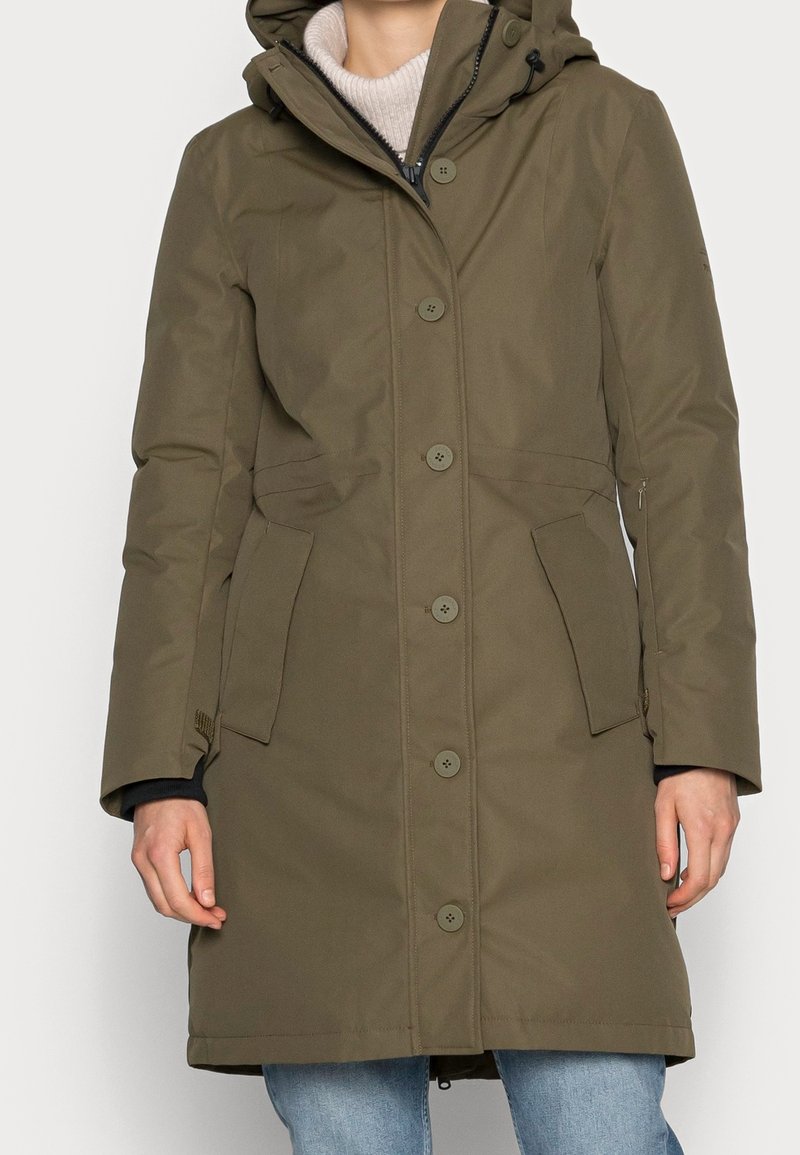 Olivgrön, lång isolerad kappa med huva, framskjutande knäppning, sidofickor och justerbara dragsnören vid halsen.