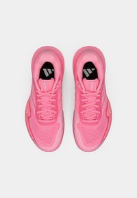 Ροζ αθλητικά παπούτσια με επάνω μέρος από αεριζόμενο δίχτυ, μαξιλαρωμένη γλώσσα και υφή στη σόλα, με αντανακλαστικές λεπτομέρειες και κορδόνια.