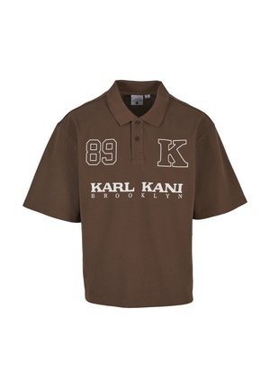 Brązowa koszulka polo z krótkim rękawem i kołnierzykiem zapinanym na guziki, białe napisy "89," "K" oraz "KARL KANI BROOKLYN" z przodu.