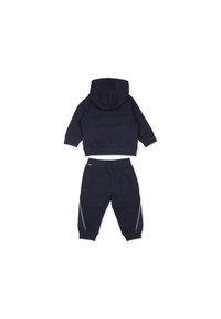 Ensemble en coton bleu marine composé d'un sweat à capuche à manches longues et d'un pantalon de jogging assorti avec des accents de rayures blanches sur les côtés.