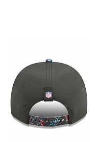 Schwarze Baseballmütze mit perforierter Textur, ausgestattet mit einem bunten Spritzmuster am verstellbaren Riemen und einem NFL-Logo-Patch.