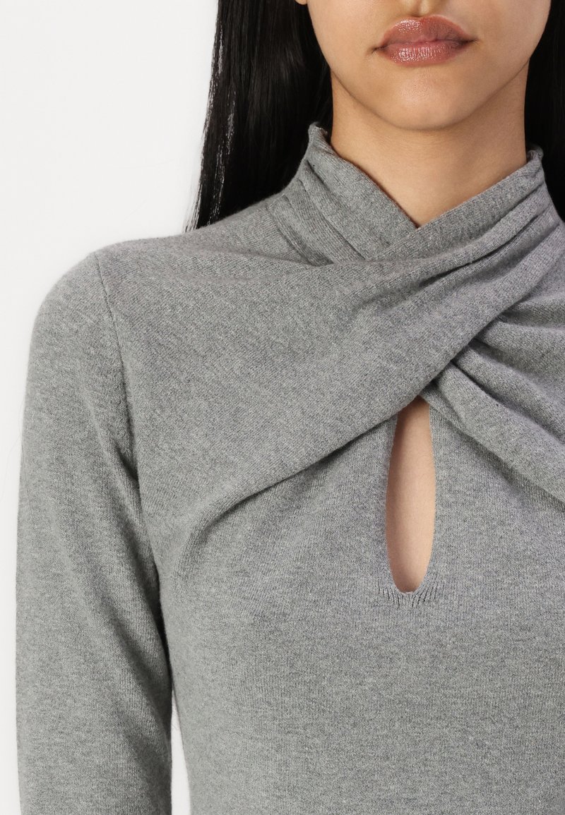 Graues Langarmoberteil aus weichem Material, mit einem gedrehten Design am Ausschnitt und einem kleinen Schlüsselloch-Ausschnitt auf der Brust.