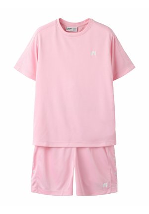 Conjunto de camisa de manga corta rosa suave y shorts a juego con pequeños logotipos blancos en el pecho y la pierna, exhibido sobre fondo blanco.