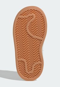 Podesva gumové boty v barvě světle hnědé s cik-cak vzorem textury, vybavená zakřiveným zářezem a tvarovaným designem pro lepší přilnavost a pohodlí.