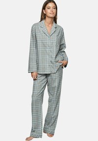 Ensemble de pyjama à carreaux gris avec des accents bleu clair, comprenant une chemise à boutons avec une poche et un pantalon ample. Texture semblable au coton.
