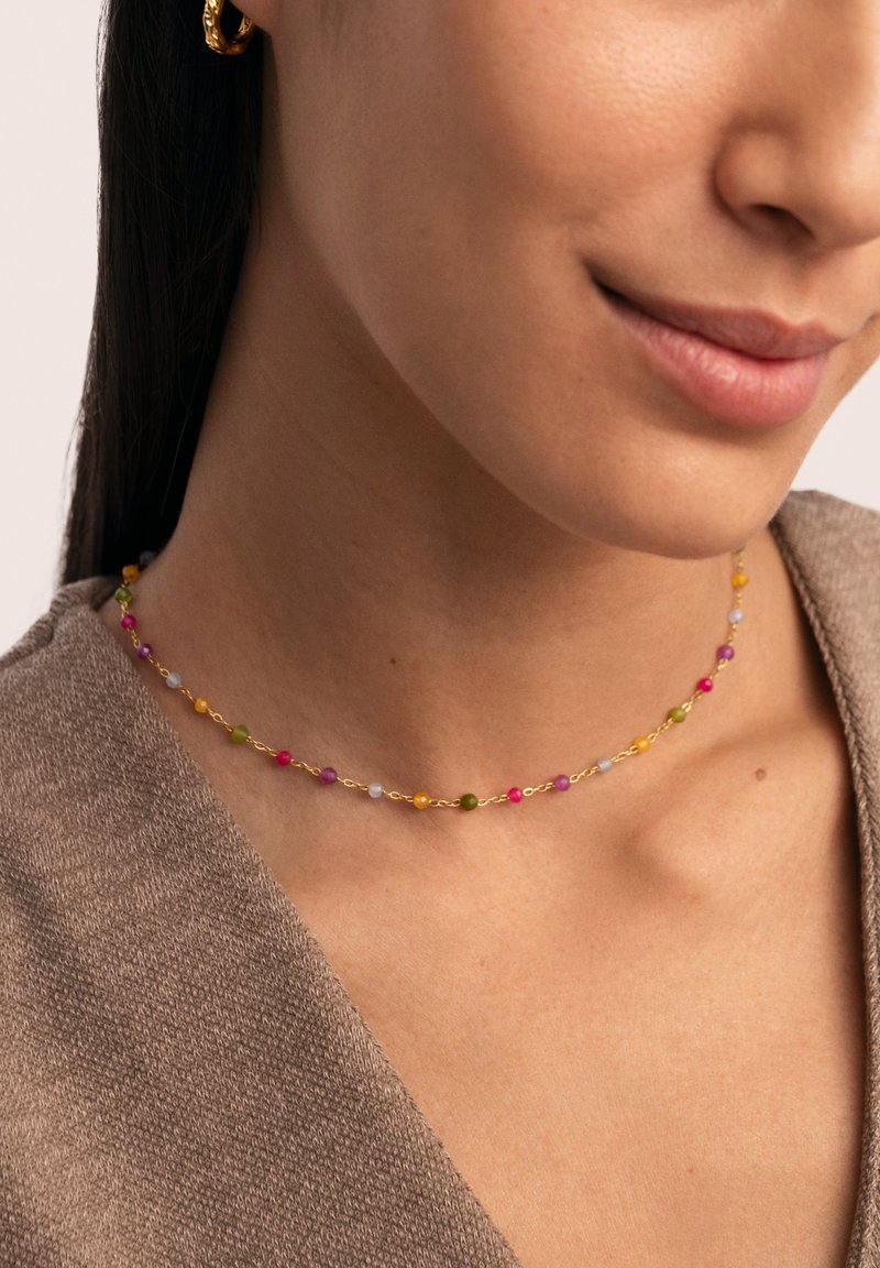 Bunte Perlen-Choker-Halskette mit rosa, grünen, gelben und blauen Perlen, an einer zarten goldenen Kette. Eng um den Hals getragen.