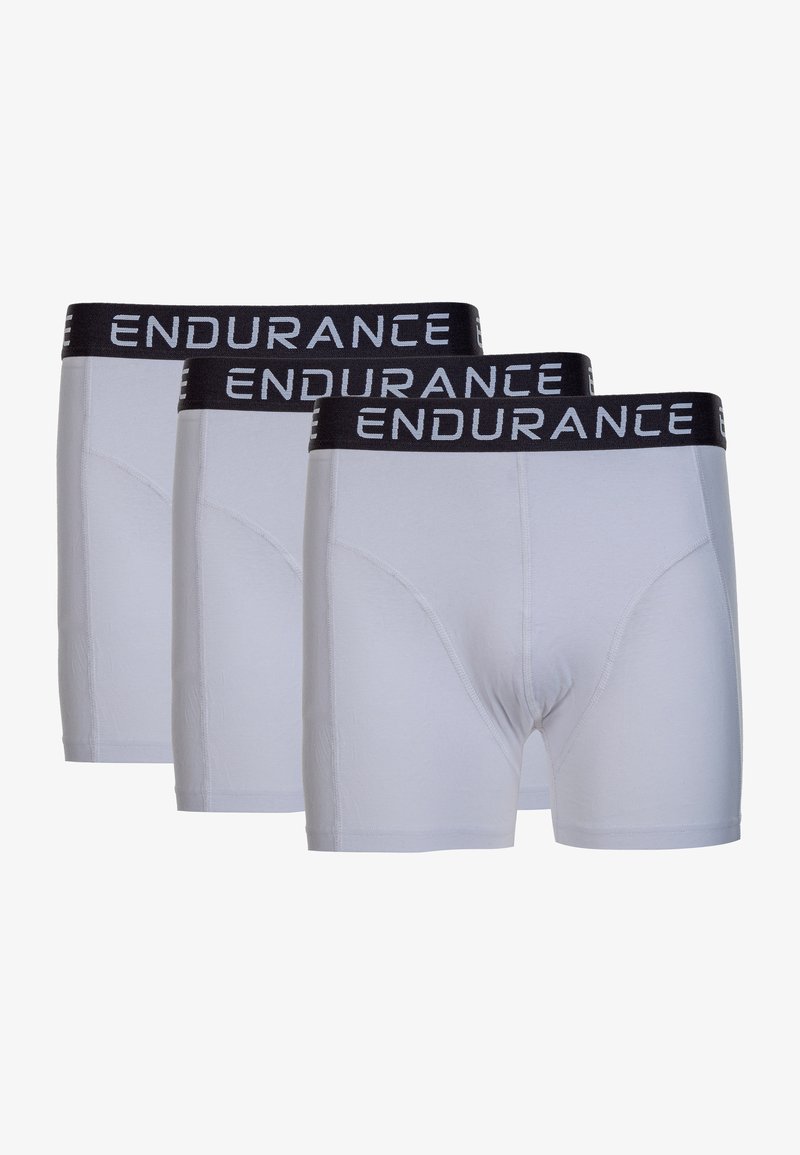 Trois paires de slips blancs avec une ceinture élastique noire portant le mot "ENDURANCE" imprimé en blanc. Texture lisse et design ajusté.