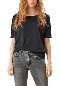 Black short-sleeve top with a relaxed fit, paired with gray denim jeans featuring a two-button closure and faded texture.