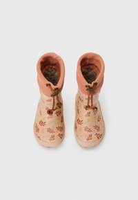 Bottes de pluie avec un col doux de couleur pêche, un extérieur beige à motifs avec des designs de feuilles rouges, et des lacets bruns pour un ajustement réglable.