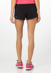 Svarta träningsshorts med randig accent, lättviktsmaterial och reflekterande detaljer, kombinerade med färgglada löparskor.