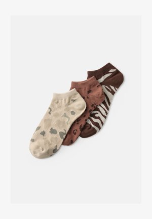Tres pares de calcetines tobilleros: beige con patrón de camuflaje, marrón con manchas y marrón oscuro con rayas de cebra; textura suave y de punto.