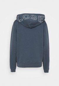 Felpa blu scuro con una grande grafica bianca "LOSE" sul retro. Caratterizzata da cappuccio, maniche lunghe e polsini e orlo a coste. Texture morbida.