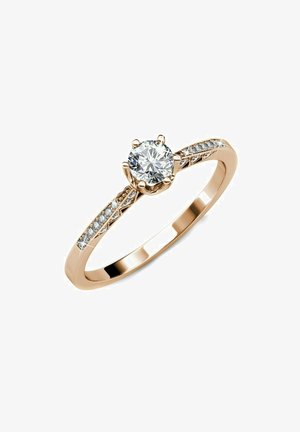 Bague en or rose avec une pierre centrale en diamant rond, flanquée de petits diamants le long de l'anneau. Fini lisse avec des détails délicats.