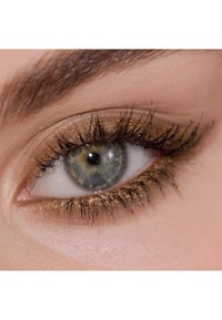 Närbild av ett öga med guldögonskugga, långa svarta ögonfransar och en blågrön iris, med distinkta texturer och färger.