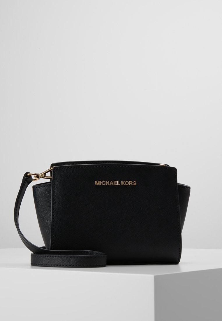 Černá kožená kabelka se strukturovaným designem, zlatými kovovými detaily a odnímatelným popruhem. Na přední straně se nachází logo Michael Kors.
