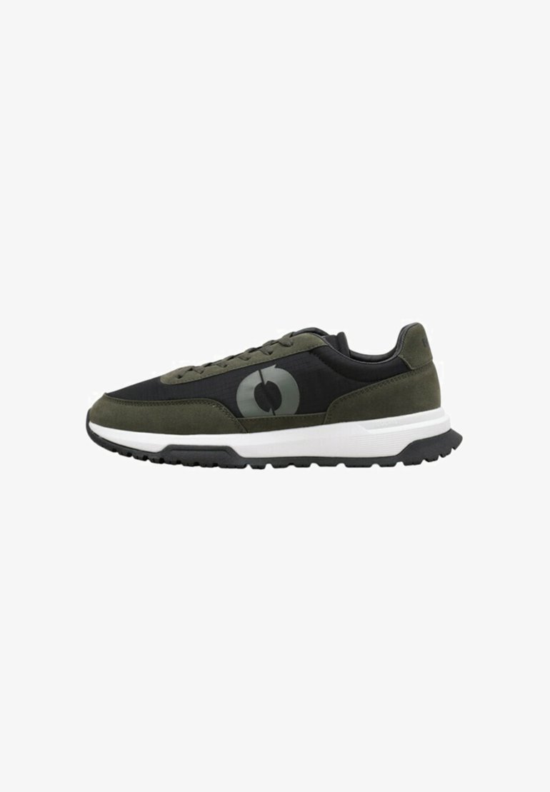 Zapatillas deportivas con un upper de tela negra, acentos de ante verde oliva, un logo prominente y una suela blanca y negra. Patrón de banda de rodadura texturizado.