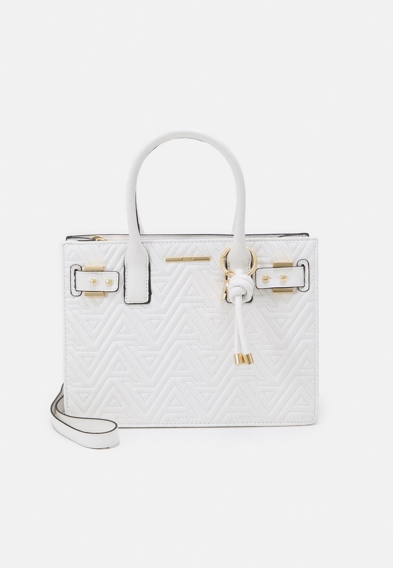 Sac à main en cuir blanc avec motif géométrique matelassé, deux poignées, ferrures dorées, nœud décoratif et bandoulière amovible.