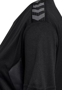 Svart idrottströja med korta ärmar, med textil med struktur, en slät axelpanel och reflexdetaljer på axeln.