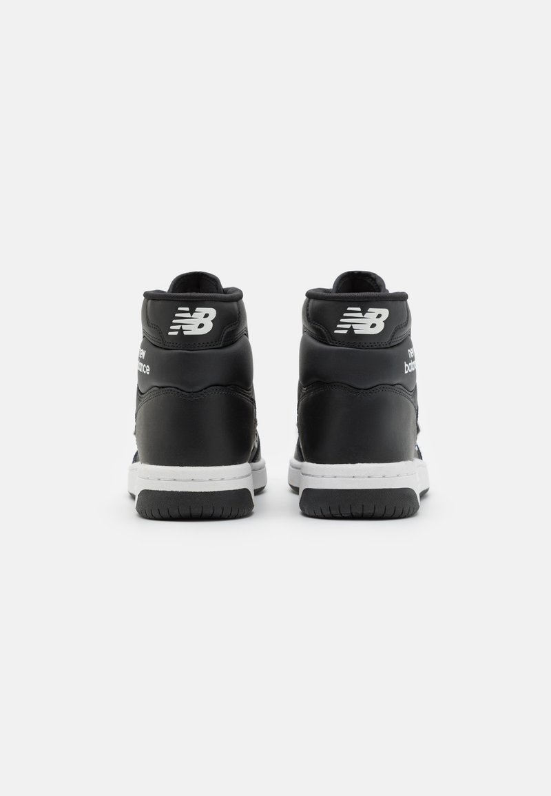 Schwarze High-Top-Sneaker mit weißen Akzenten, ausgestattet mit einem glatten Lederoberteil, gepolstertem Kragen und strukturiertem Gummisohl. New Balance-Logo sichtbar.