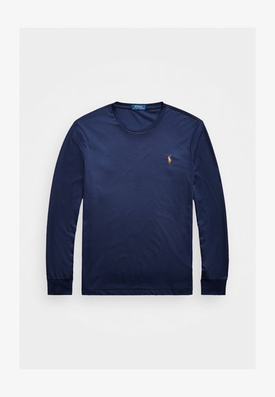 Temno moder dolg rokav majica iz mehkega materiala, z okroglo ovratnikom in rebrastimi manšetami, s majhnim vezenim logotipom na levi prsni strani.