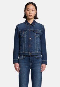 Giacca di jeans blu scuro, con colletto classico, chiusura frontale con bottone, due tasche sul petto e dettagli di cucitura bianchi.