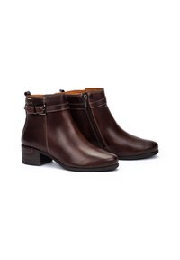 Botines de cuero marrón con punta redonda, tacón bajo en bloque, cremallera lateral y costuras decorativas a lo largo del cuello y el tacón.