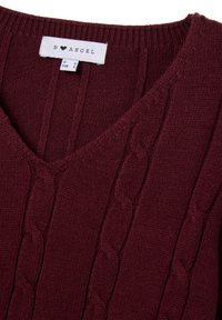 Burgunderfarbener Strickpullover mit V-Ausschnitt, der ein Zopfmuster und gerippte Kanten aufweist. Das Etikett trägt die Aufschrift "B ♥ ANGEL", Größe EU S.