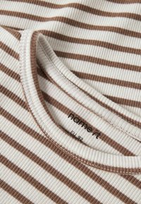 Zbliżenie na T-shirt z prążkowanej dzianiny w poziome paski w kolorze brązowym i białym, z okrągłym dekoltem, pokazujący metkę marki i rozmiar UE 92.