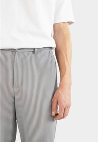Grau gestreifte Hose aus leichtem Stoff, mit slim fit Design, Gürtelschlaufen und einer einzelnen Vordertasche.