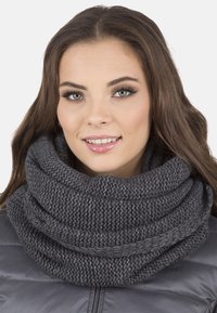 Écharpe infinity grise tricotée avec un motif texturé, épaisse et douce, portée confortablement autour du cou, ajoutant chaleur et style.