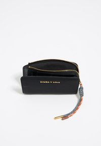 Cartera negra con cremallera, hecha de un material texturizado. Presenta herrajes dorados y un tirador de cremallera trenzado de varios colores. Logo grabado en la parte frontal.