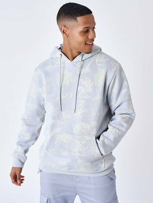 Haut de survêtement bleu clair en tissu doux, avec un motif de nature blanc sur toute la surface, capuche avec cordon de serrage et poche kangourou à l'avant.