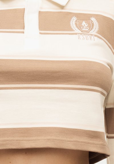 Κρεμ και λευκό ριγέ κοντομάνικο πόλο πουκάμισο με γιακά και κεντημένο έμβλημα στο στήθος.