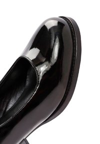 Zwarte patenten leren schoen met een ronde neus en uitsnijding. Beschikt over een gladde, glanzende oppervlakte en een subtiele, duurzame zool.