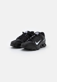 Zapatillas deportivas negras con parte superior de malla transpirable, suela de goma y logo de Nike en blanco, que cuentan con un cierre de cordones y un acolchado en el collar.