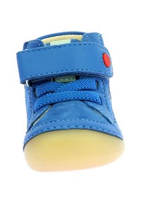 Scarpa sintetica blu con cinturino in Velcro, superficie testurizzata, punta arrotondata e suola in gomma gialla. Presenta lacci blu e dettagli di cucitura.