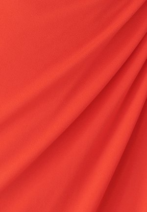 Bright red fabric with a smooth, slightly textured surface, showing folds and drapes, suitable for clothing or upholstery.