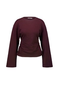 Camiseta de cuello redondo de manga larga en color púrpura oscuro con un pequeño logo bordado en el lado izquierdo del pecho sobre un fondo blanco.